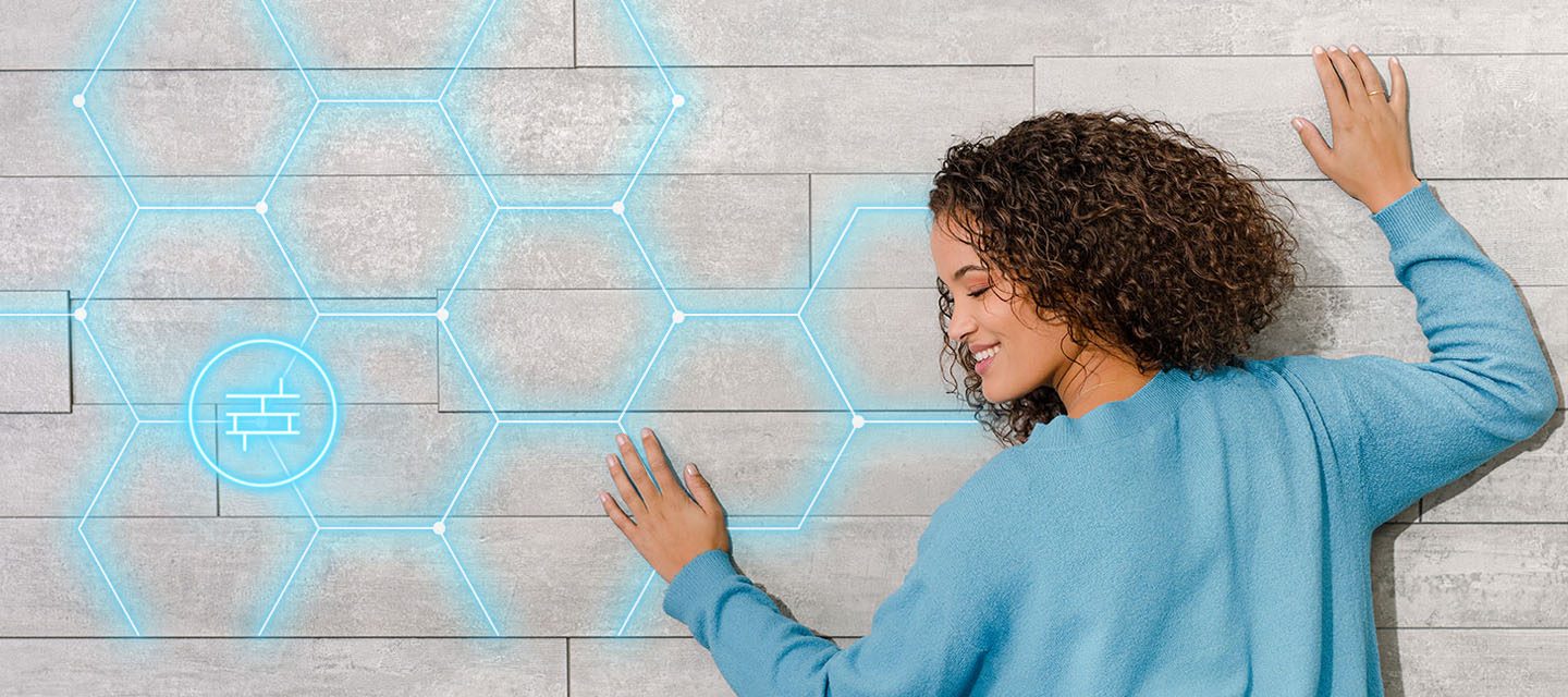 A woman with her head against a wall which has light blue pentagons highlighted